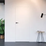 Portas ocultas HIDE: exemplo de porta branca integrada na parede de uma sala
